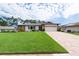 A well-maintained home with a green lawn, brick driveway, and a two-car garage at 2174 Kent Ave, Clearwater, FL 33764