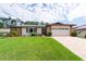 Charming single-story home featuring a lush green lawn and stone accents at 2174 Kent Ave, Clearwater, FL 33764