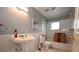 Bathroom with a pedestal sink, tiled shower, and natural light at 21921 Us Highway 98, Dade City, FL 33523