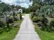 Charming driveway framed by lush greenery and palm trees, leading to the beautiful home in the background at 21921 Us Highway 98, Dade City, FL 33523