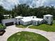 Stunning aerial view of white stucco home, lush landscaping, and a paved driveway leading to an attached garage at 21921 Us Highway 98, Dade City, FL 33523