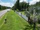 Showcasing the property line along a quiet street, framed by a white fence and lush green landscape at 21921 Us Highway 98, Dade City, FL 33523