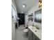 Updated bathroom featuring a shower with black tile, a sink with gold fixtures, and decorative shelving at 2509 Thornbrook Pl, Tampa, FL 33618