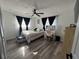 Bedroom with wood floors, desk, windows with black curtains, ceiling fan and bench seat at 2509 Thornbrook Pl, Tampa, FL 33618