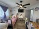 ' bedroom with twin beds, wood-look flooring, ceiling fan, and flatscreen TV above a vanity at 2509 Thornbrook Pl, Tampa, FL 33618