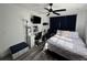 Bedroom featuring wood floors, ceiling fan, windows with black curtains, and a desk with drawers at 2509 Thornbrook Pl, Tampa, FL 33618