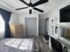 Bedroom features wood floors, a ceiling fan, desk, and built-in storage, with gray doors and dark curtains at 2509 Thornbrook Pl, Tampa, FL 33618