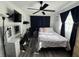 Bedroom features wood floors, a ceiling fan, and a desk with drawers next to a queen bed and black curtains at 2509 Thornbrook Pl, Tampa, FL 33618
