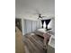 Bedroom featuring wood floors, ceiling fan, gray louvered closets, large windows with black curtains, and office space at 2509 Thornbrook Pl, Tampa, FL 33618