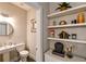 Stylish half bathroom featuring a modern sink, a round mirror, and decorative shelving at 2568 13Th N Ave # 2568, St Petersburg, FL 33713