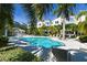 Exterior view of a community pool surrounded by tropical foliage and lounging areas at 2568 13Th N Ave # 2568, St Petersburg, FL 33713