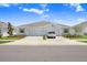 A modern duplex showcasing a well-kept front yard and a clean driveway with car parked in front of the garage at 31426 Ancient Sage Rd, Wesley Chapel, FL 33545