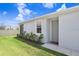 Home exterior features a manicured lawn, mulch landscaping, and a gray front door with modern minimalist architecture at 31426 Ancient Sage Rd, Wesley Chapel, FL 33545