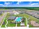 A stunning aerial view features the community pool, clubhouse, and playground surrounded by lush landscaping at 31426 Ancient Sage Rd, Wesley Chapel, FL 33545
