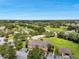 Beautiful aerial view of property with pond, lush green landscaping, and parking at 36243 Lake Chase Blvd # 102, Zephyrhills, FL 33541