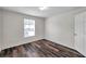 Bedroom with wood-look floors, natural light from a window, and a standard closet at 36243 Lake Chase Blvd # 102, Zephyrhills, FL 33541