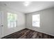 Bedroom featuring wood-look floors, natural light from dual windows, and closet at 36243 Lake Chase Blvd # 102, Zephyrhills, FL 33541