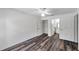 Bright bedroom with wood-look floors, ceiling fan, and convenient access to a closet and bathroom at 36243 Lake Chase Blvd # 102, Zephyrhills, FL 33541