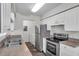 Bright kitchen with stainless steel refrigerator and stove complemented by white cabinets and wood-look flooring at 36243 Lake Chase Blvd # 102, Zephyrhills, FL 33541