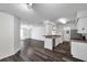White kitchen with stainless steel appliances boasts hardwood flooring and a breakfast bar at 36243 Lake Chase Blvd # 102, Zephyrhills, FL 33541