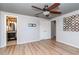 Open bedroom with laminate flooring, ceiling fan, fresh paint, a double closet, and access to the bathroom at 3628 Holiday Lake Dr, Holiday, FL 34691