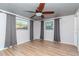 Bright and airy bedroom with laminate flooring, ceiling fan, large windows, and light gray walls at 3628 Holiday Lake Dr, Holiday, FL 34691