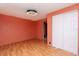 Spacious bedroom with laminate flooring, a ceiling fan, fresh paint, and a closet with sliding doors at 3628 Holiday Lake Dr, Holiday, FL 34691