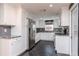 Well-lit modern kitchen with stainless steel appliances, granite countertops, white cabinets, and dark tile flooring at 3628 Holiday Lake Dr, Holiday, FL 34691