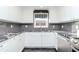 Beautiful kitchen featuring white cabinets, granite countertops, grey tile backsplash, and stainless steel appliances at 3628 Holiday Lake Dr, Holiday, FL 34691
