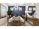 Elegant dining room featuring tile floors, a modern chandelier, and an accent wall at 3840 Consolare Ct, Wesley Chapel, FL 33543