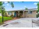 Charming single-story home with a well-manicured lawn, arched entry, and inviting turquoise front door at 3909 W Lemon St, Tampa, FL 33609
