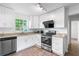 Updated kitchen with stainless appliances, granite counters, white cabinets, and modern lighting at 3909 W Lemon St, Tampa, FL 33609