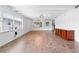 Open-concept living room with wood floors, white walls and ceiling beams, updated lighting, and large windows at 3909 W Lemon St, Tampa, FL 33609