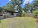 Landscaped backyard with a covered patio and a charming picket fence at 4030 Braesgate Ln, Tampa, FL 33624