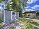 View of backyard shed next to covered wooden patio with nice landscaping at 4030 Braesgate Ln, Tampa, FL 33624