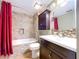 Well-lit bathroom showcasing a tiled shower-tub, modern vanity, and a decorative shower curtain at 4030 Braesgate Ln, Tampa, FL 33624