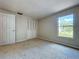 A bright carpeted bedroom with a closet and a window, offering a simple and comfortable space at 4030 Braesgate Ln, Tampa, FL 33624