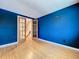 Stylish bedroom with hardwood floors, blue walls, and a glass french door to another room at 4030 Braesgate Ln, Tampa, FL 33624