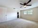 This bedroom includes neutral carpet, a ceiling fan, and natural light from the large window at 4030 Braesgate Ln, Tampa, FL 33624