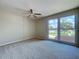 Bright bedroom featuring a ceiling fan, large window with a view, and neutral carpet at 4030 Braesgate Ln, Tampa, FL 33624