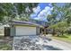 Two-story home featuring a two-car garage, a welcoming pergola, and beautifully landscaped front yard at 4030 Braesgate Ln, Tampa, FL 33624