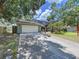 Charming two-story home with a well-manicured lawn, mature trees, and a two-car garage at 4030 Braesgate Ln, Tampa, FL 33624