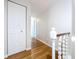 Bright hallway featuring hardwood floors, closet doors, and white trim at 4030 Braesgate Ln, Tampa, FL 33624