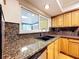 Kitchen detail showcasing granite countertops, stainless steel dishwasher, modern sink and wood cabinets at 4030 Braesgate Ln, Tampa, FL 33624