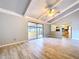 Open living room with vaulted ceiling, ceiling fan, sliding glass doors to the lanai and hardwood-style floors at 4030 Braesgate Ln, Tampa, FL 33624