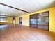 Large, brightly lit enclosed patio with laminate flooring and multiple sliding glass doors, creating a seamless indoor-outdoor flow at 4030 Braesgate Ln, Tampa, FL 33624