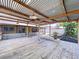 A covered wood patio overlooking the backyard with metal roof and wood beams for natural beauty at 4030 Braesgate Ln, Tampa, FL 33624