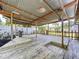 A covered wood patio with lush backyard and white picket fence, ideal for outdoor living at 4030 Braesgate Ln, Tampa, FL 33624