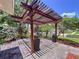 Outdoor dining area features a pergola, brick floor, and potted plants with a view to the neighborhood street at 4030 Braesgate Ln, Tampa, FL 33624