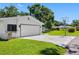 Garage exterior with a basketball hoop on a sunny day, surrounded by lush greenery and blue skies at 4391 Ne Cherry Ne St, St Petersburg, FL 33703